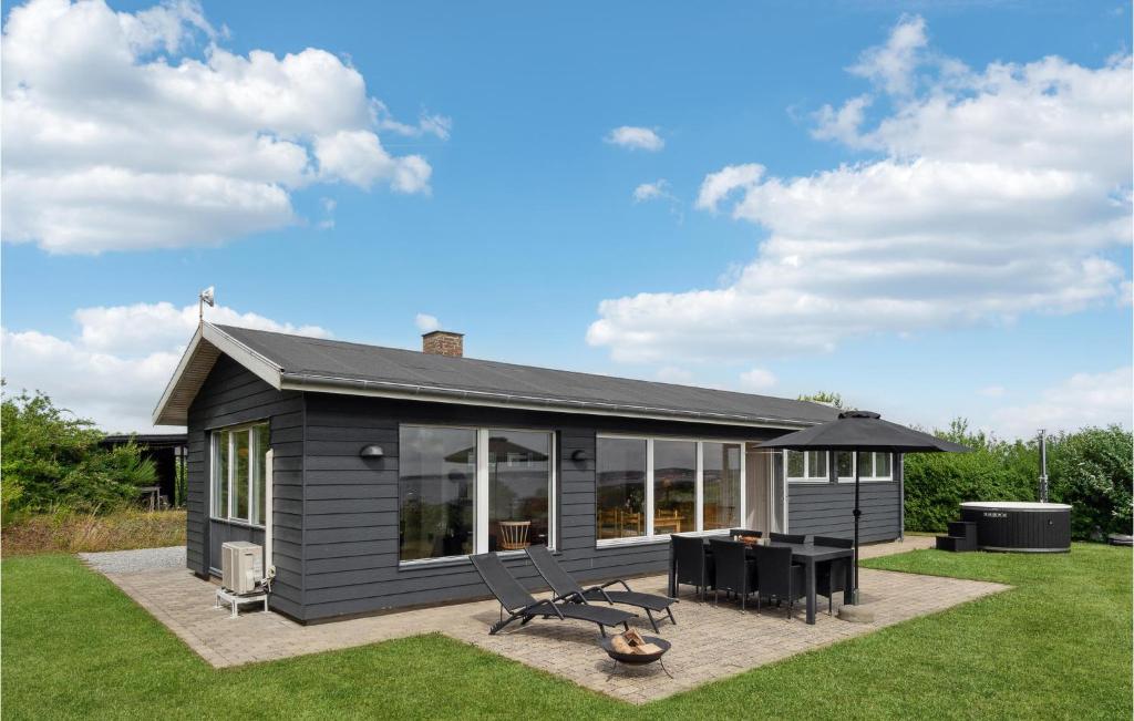 ein kleines graues Haus mit einem Picknicktisch und Stühlen in der Unterkunft 3 Bedroom Beautiful Home In Ebeltoft in Ebeltoft