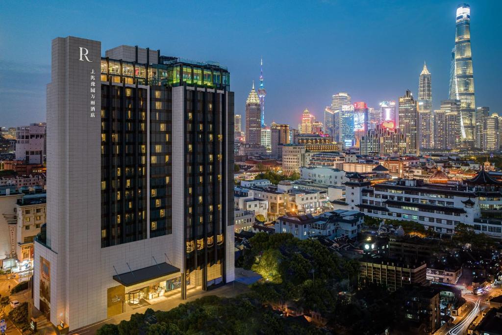 رونيسانس شنغهاي يو غاردن  في شانغهاي: مبنى طويل مع أفق المدينة في الليل