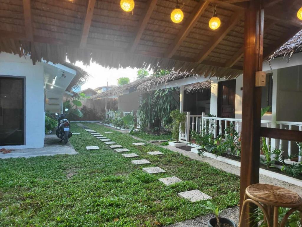 a patio of a house with a motorcycle parked in the yard at LALUNA COTTAGES in El Nido