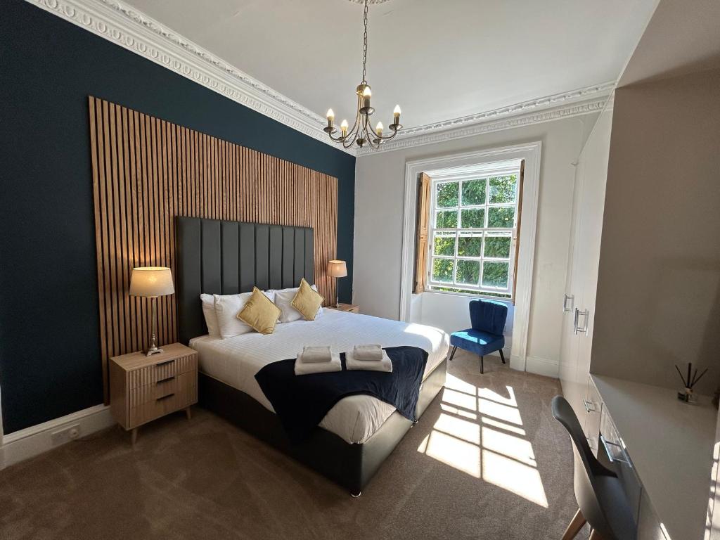 a bedroom with a large bed and a chandelier at Principal Apartments - Crown Circus Duplex Apartment in Glasgow