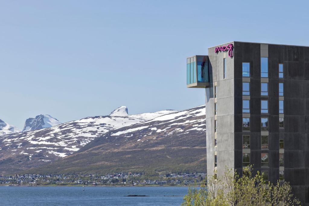 a building with graffiti on it in front of a mountain at Moxy Tromso in Tromsø