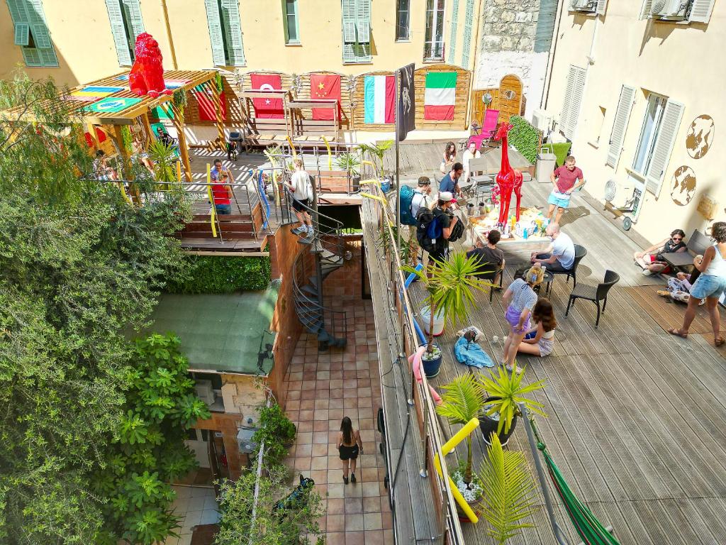 eine Gruppe von Menschen, die auf einem Deck in einem Gebäude sitzen in der Unterkunft Antares hostel in Nizza