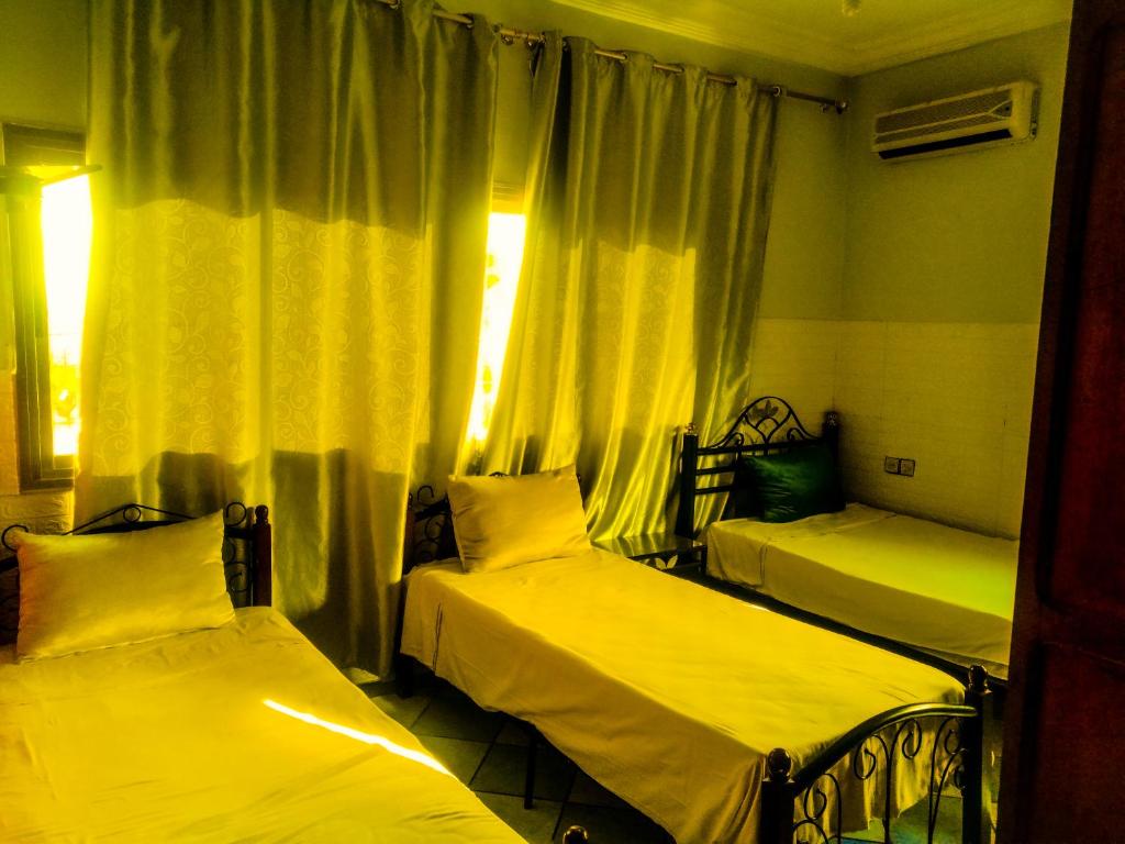 a room with two beds and a window at Hotel Complex Europe in Guercif