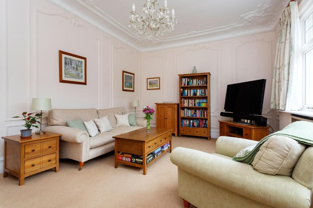 een woonkamer met een bank en een tv bij Veeve - Courtside Dreams in Londen