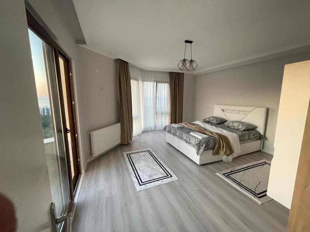 sypialnia z łóżkiem i dużym oknem w obiekcie Parlayan Suite Trabzon w mieście Akcaabat