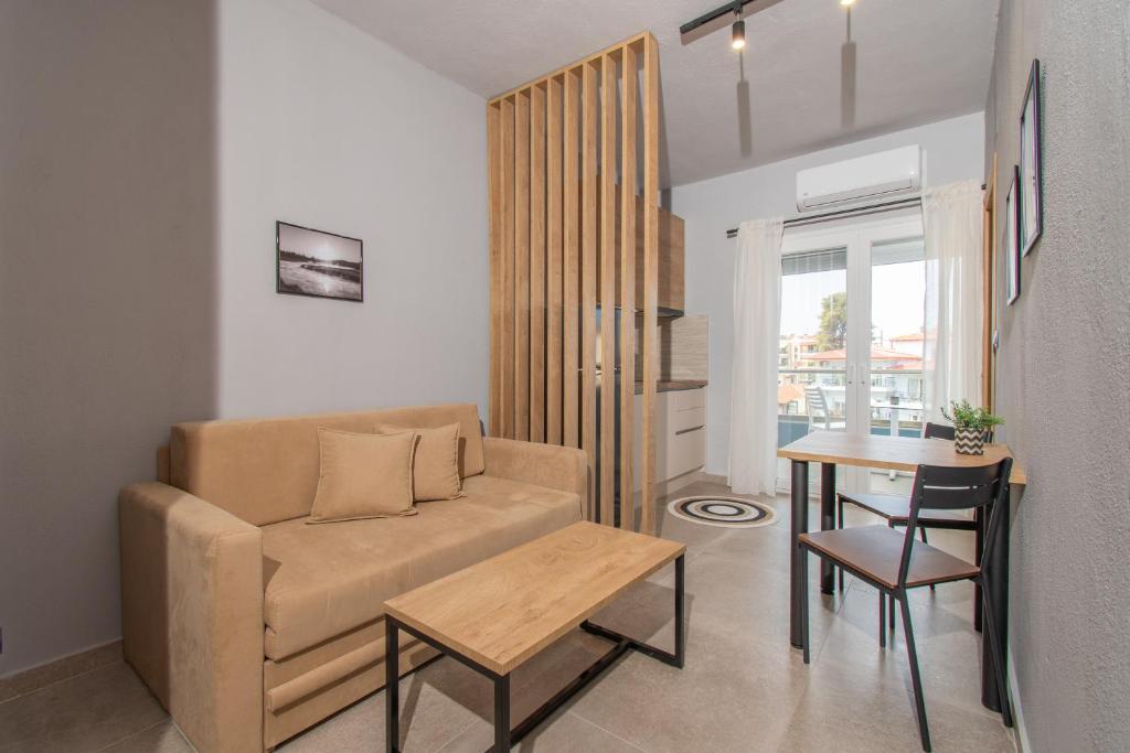 salon z kanapą i stołem w obiekcie Unique Aura Luxury Studios w mieście Neos Marmaras