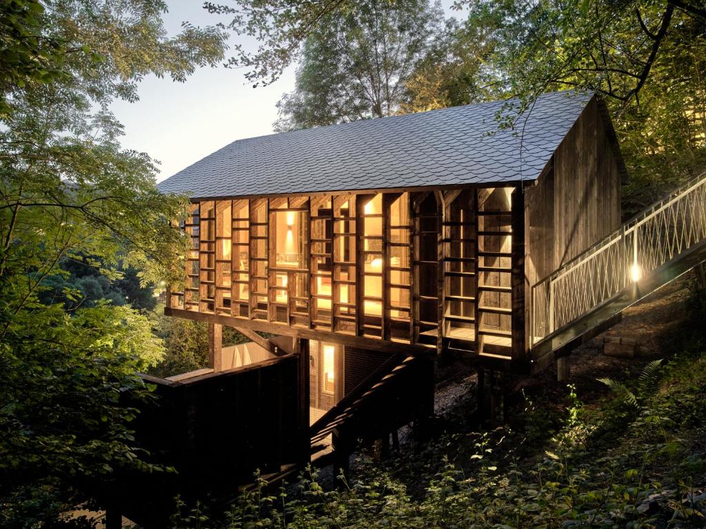 ein Holzhaus im Wald mit schwarzem Dach in der Unterkunft Hutstuf The Beaver & Private Outdoor Spa in La-Roche-en-Ardenne