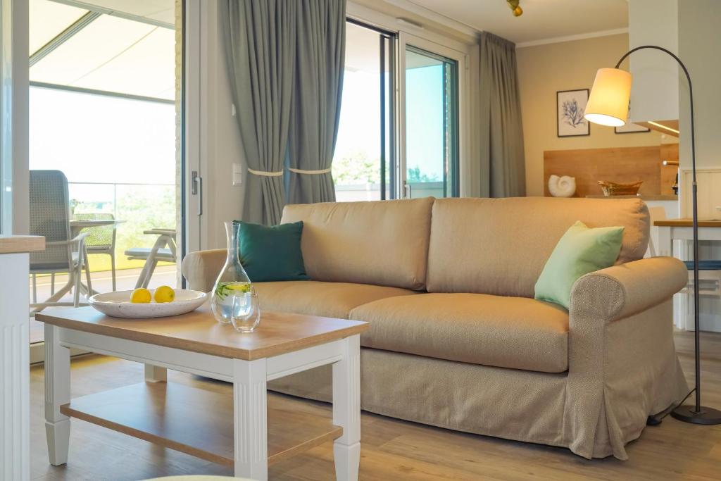 a living room with a couch and a table at Appartements "Zum Leuchtturm" Hafen Rankwitz Insel Usedom in Rankwitz