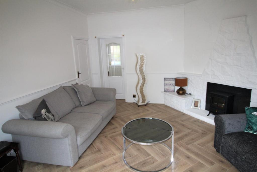 a living room with a couch and a fireplace at Whitley Bay - Sleeps 6 - Refurbished Throughout - Fast Wifi - Dogs Welcome in Whitley Bay