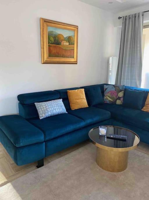 un canapé bleu dans un salon avec une table dans l'établissement 2 bedroom apartament close to the beach, à Cannes