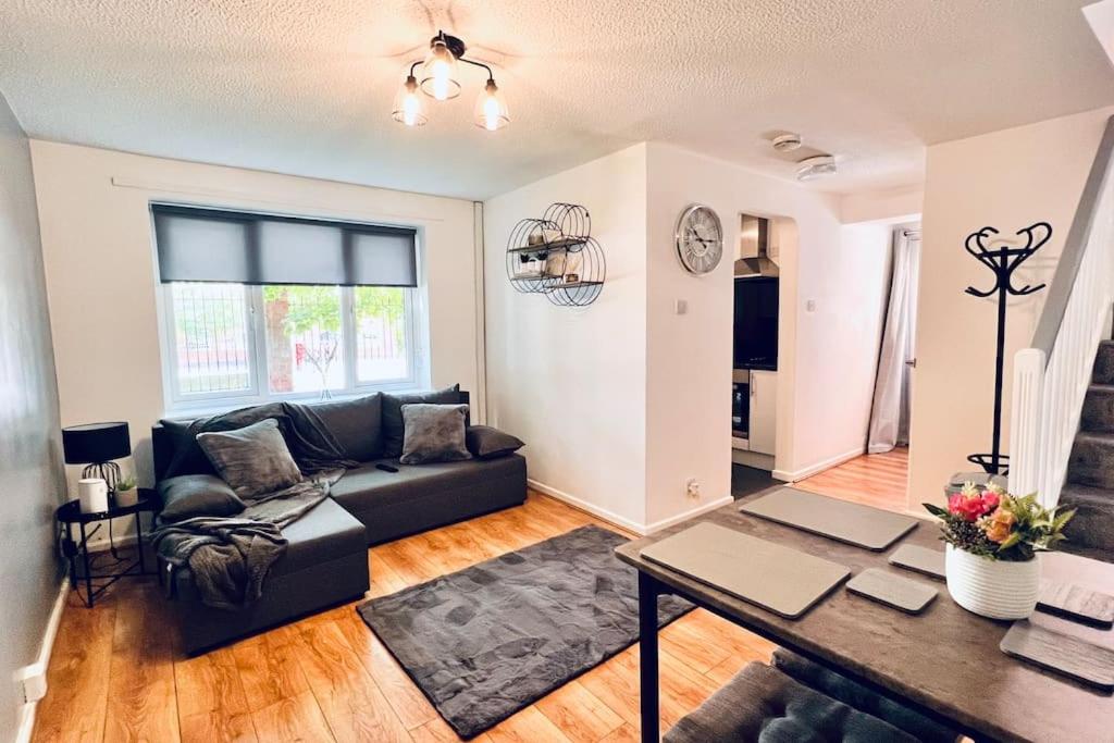 a living room with a couch and a table at Urban Bliss Stylish Townhouse with Free Parking for a Convenient City Stay in Liverpool