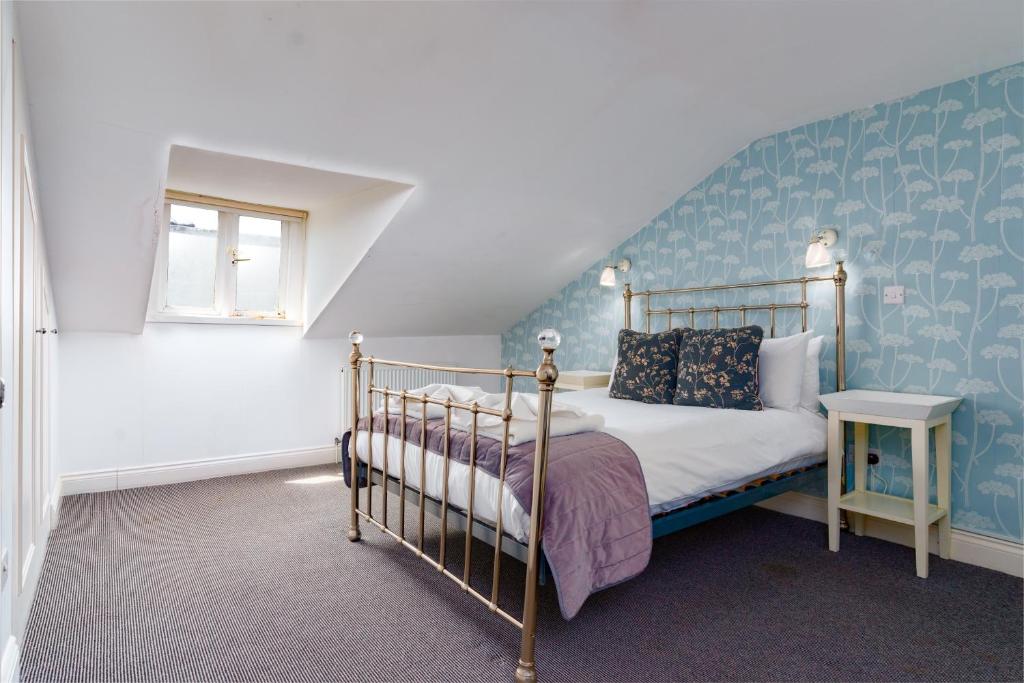 Bower House في لندن: غرفة نوم بسرير وجدار ازرق