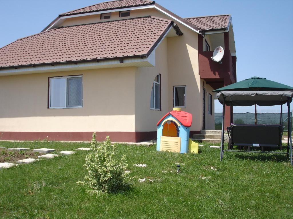 a house with a play structure in the yard at Vila Antonia in Eforie Nord