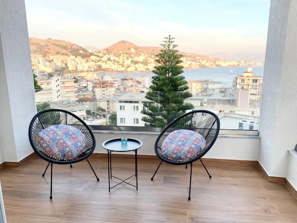 two chairs and a table in front of a window at Villa Saral Mar in Sarandë