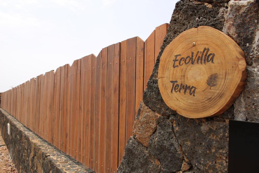 a wooden sign on the side of a wooden fence at Eco Terra by Sea You There Fuerteventura in Puerto del Rosario