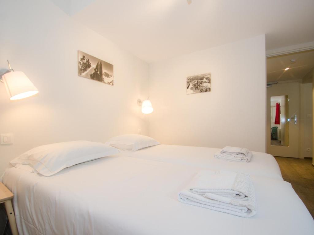 białe łóżko w pokoju z dwoma ręcznikami w obiekcie Charmant T3 rénové avec jardin, parking & wifi à Chamonix - FR-1-343-206 w Chamonix-Mont-Blanc