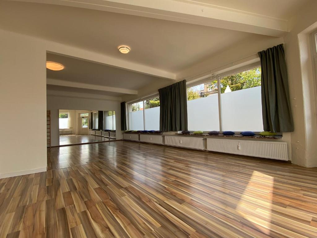 pusty pokój z drewnianą podłogą i dużymi oknami w obiekcie Studio mit Küche w mieście Pirna