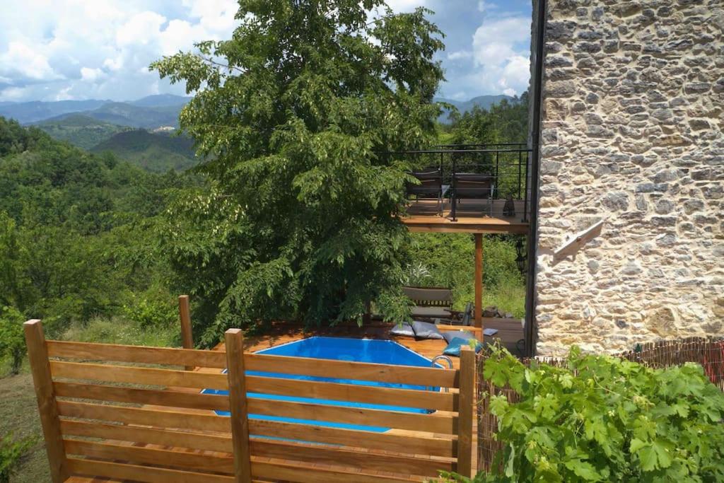 einem Holzzaun mit einem Pool vor einem Gebäude in der Unterkunft Paradis pour deux, pierres, piscine, Cinque Terre in Riccò del Golfo di Spezia