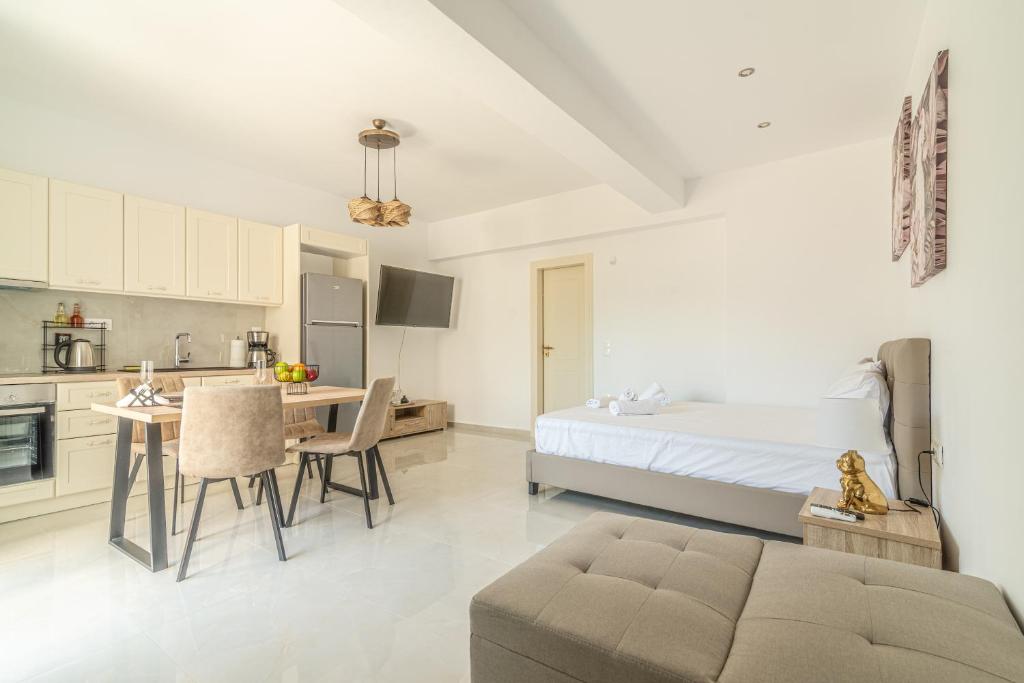 a room with a bed and a table and a kitchen at Elegant Suite 4 Near the Beach in Ayía Marína