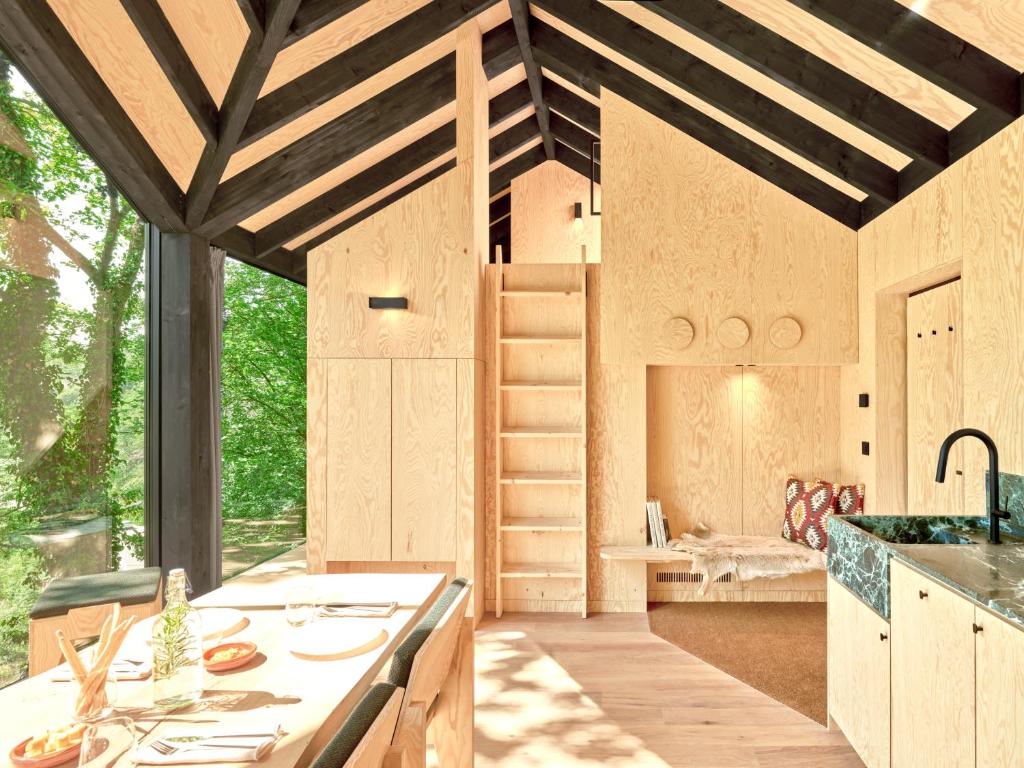 a kitchen with wooden cabinets and a large window at Hutstuf The Eagle & Private Outdoor Spa in La-Roche-en-Ardenne
