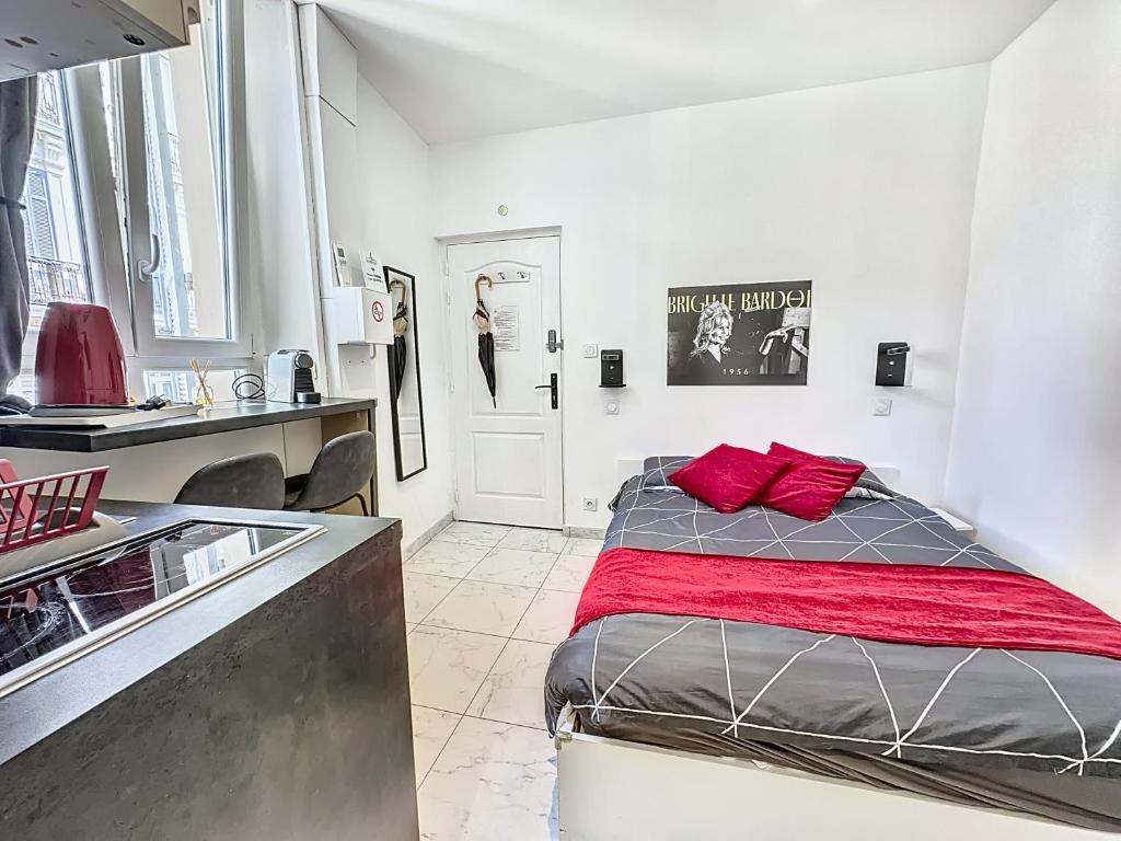 - une chambre avec un lit doté d'oreillers rouges dans l'établissement Sweet Home Marceau 6 studios hyper centre proche de la mer et du palais, à Cannes