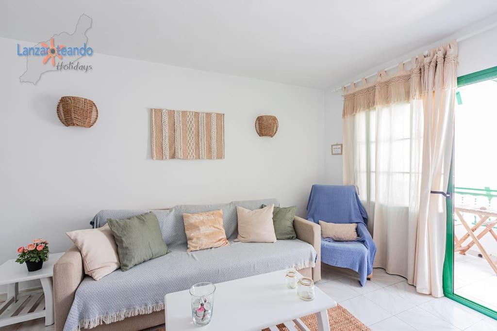 a living room with a gray couch and a blue chair at Lima Vivienda Vacacional in Puerto del Carmen