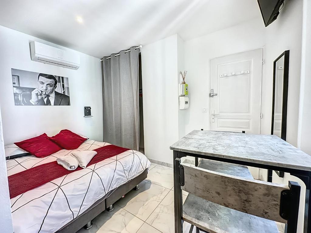 une chambre avec un lit et une table dedans dans l'établissement Sweet Home Marceau 6 studios hyper centre proche de la mer et du palais, à Cannes
