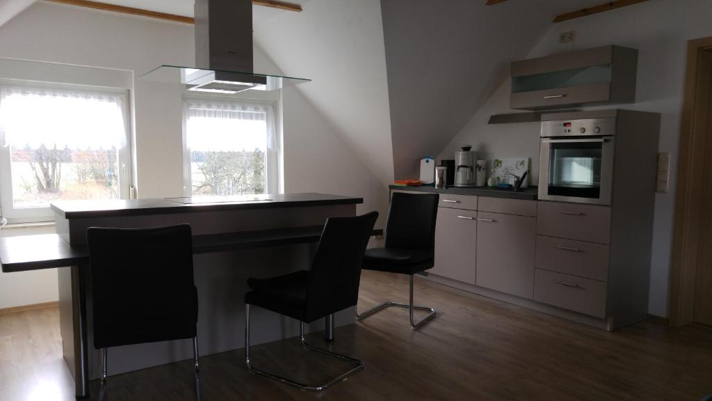 a kitchen with a counter and chairs in a room at BogottHof in Elsterheide