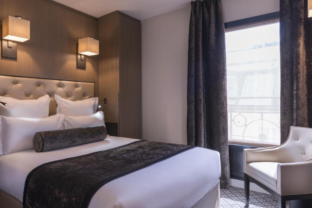 una camera d'albergo con letto e finestra di La Villa des Ternes a Parigi