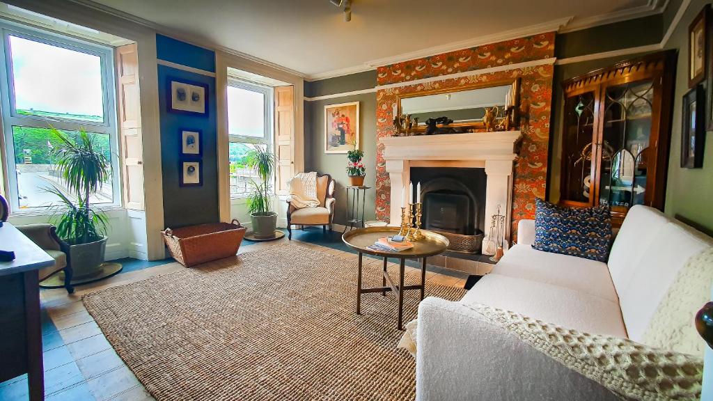 a living room with a couch and a fireplace at Rose House in Glenarm