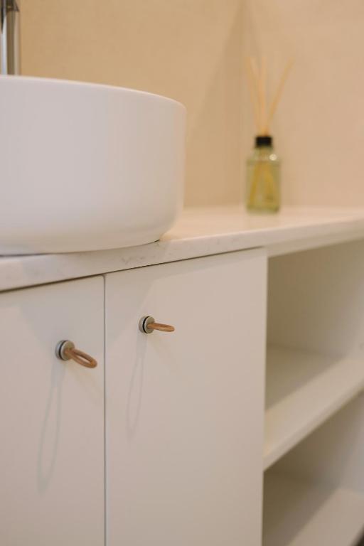 a white cabinet with a bowl on top of it at Aldoar House in Porto
