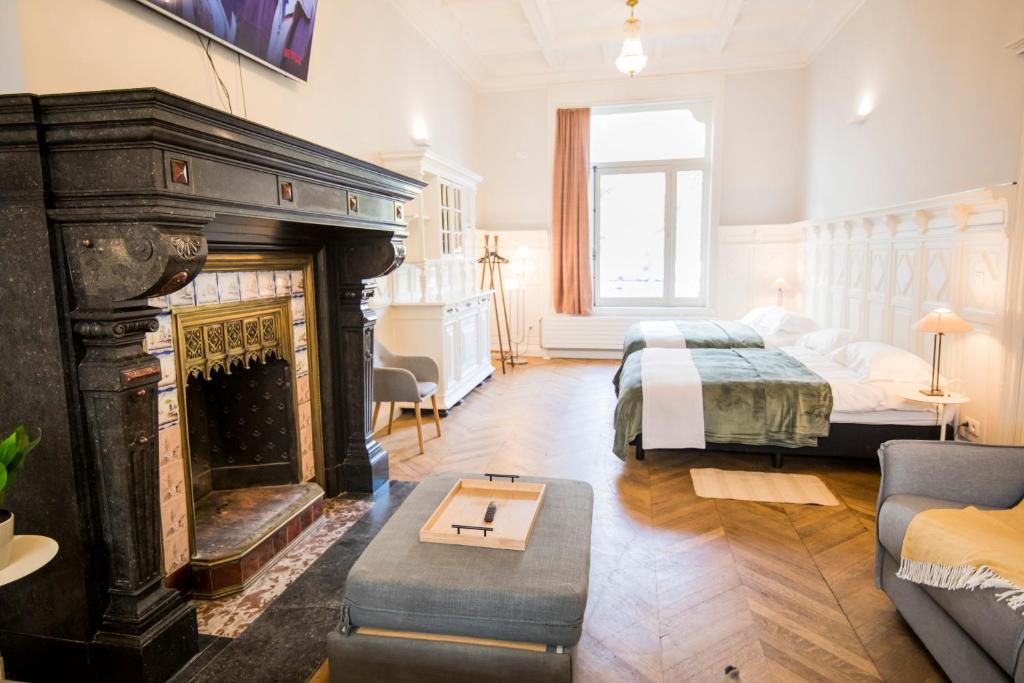 a living room with a fireplace and a bed and a room at Smart Appart - Gare Du Midi in Brussels