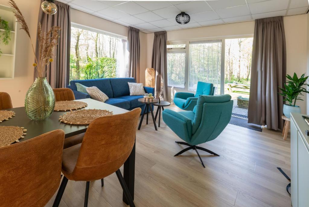 Appartement Zuiderstrand في زوتلاند: غرفة معيشة مع طاولة وكراسي