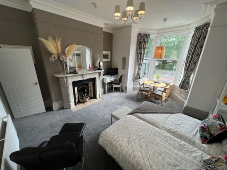 a bedroom with a bed and a living room with a fireplace at 2 Bed ground floor apartment, sleeps 4 with free parking in Harrogate