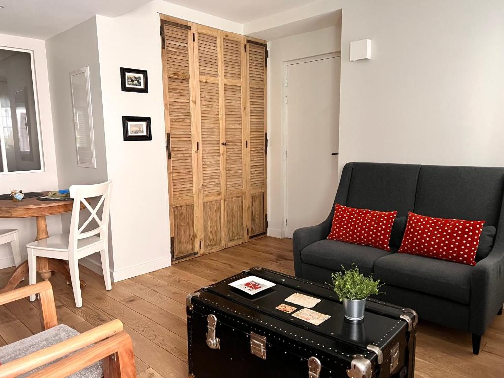 a living room with a black couch and a table at Les Petits Volets 3 appartements au choix in Antibes