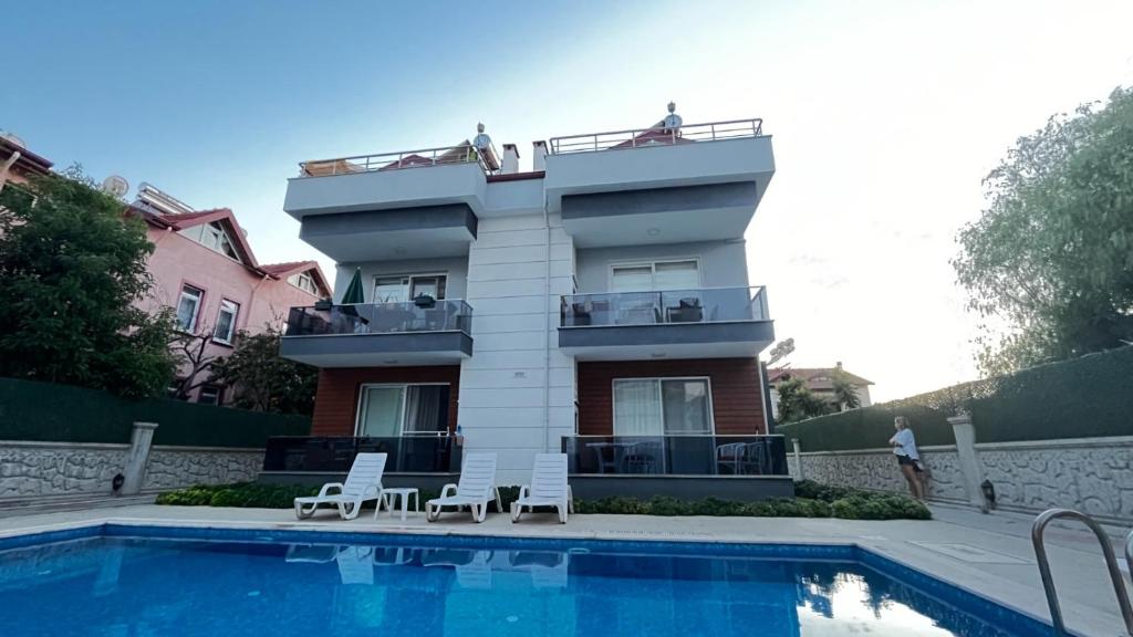 een huis met een zwembad naast een gebouw bij Elit Yaşam Site 1-Bedroom flat with pool in Fethiye