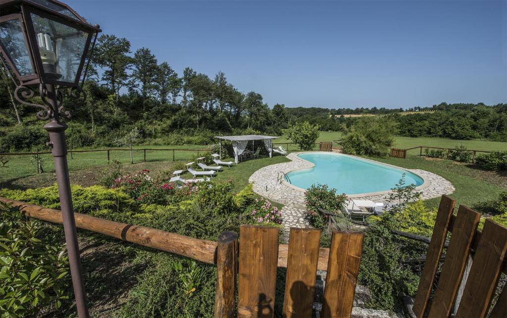Una piscina en un patio con una farola y una lámpara. en Villa degli Amanti - Homelike Villas, en Terranuova Bracciolini