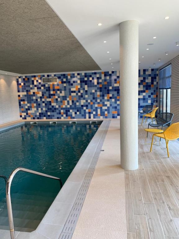 een zwembad in een gebouw met een lobby bij Résidence Services Seniors Domitys - Les Safrans in Dives-sur-Mer