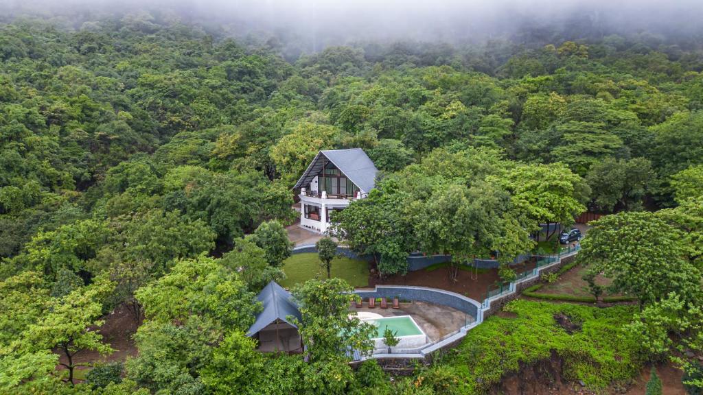 an aerial view of a house in the middle of a forest at SaffronStays Aranya Vilas & Raanwaara Cottage in Āmbavna