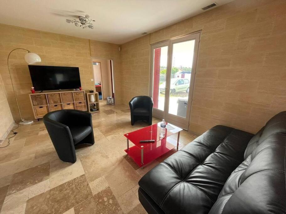 a living room with a couch and chairs and a television at Villa feng shui in Fargues-de-Langon