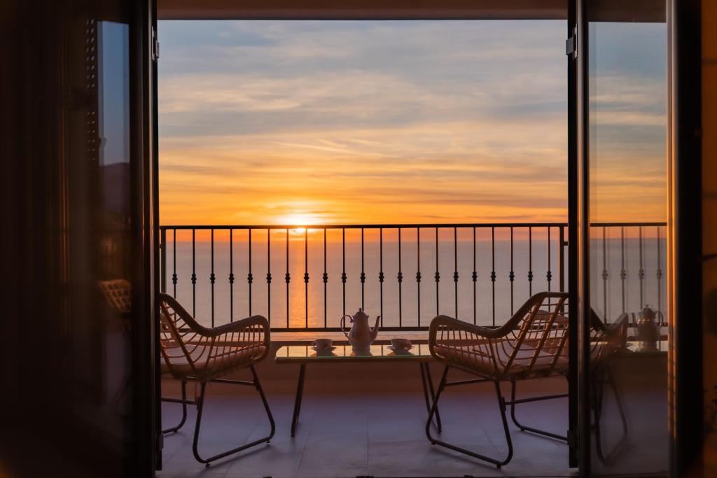 two chairs on a balcony with the sunset in the background at Villa Krstac in Budva