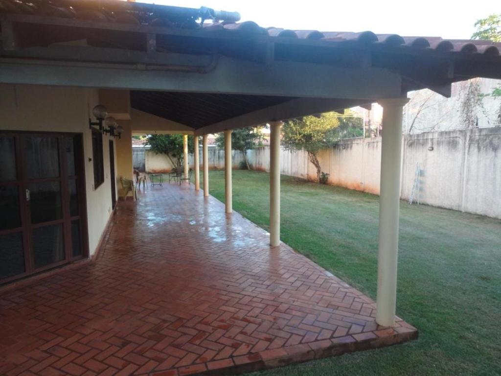 eine Außenterrasse mit Säulen und Ziegelboden in der Unterkunft Hostel da Spipe in Campo Grande