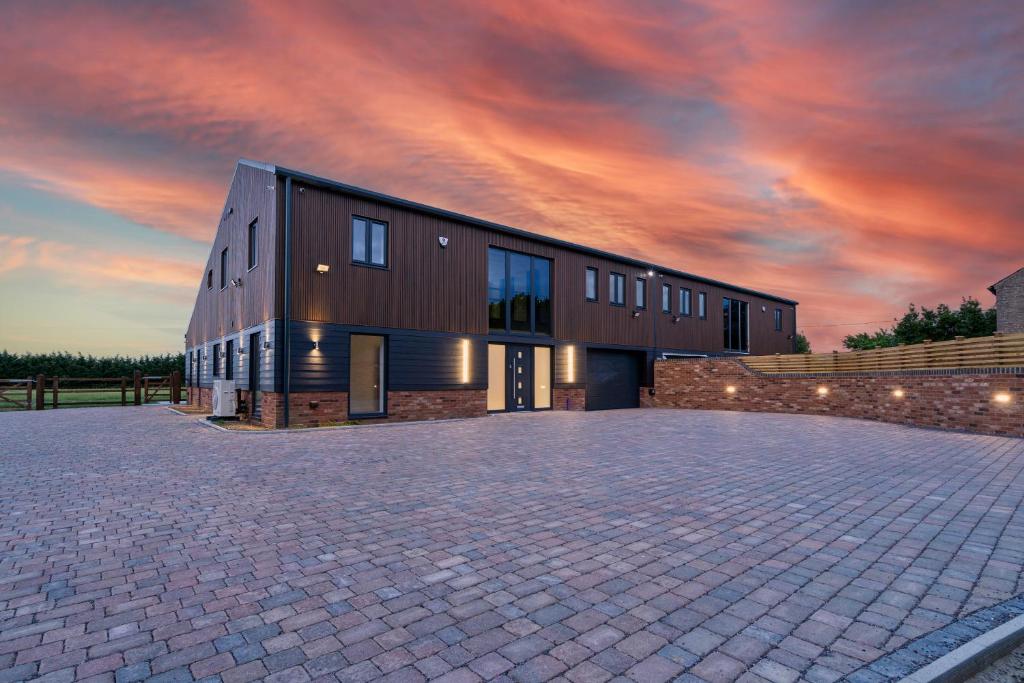 a building with a cloudy sky in the background at Brand New Barn Retreat in Bedford