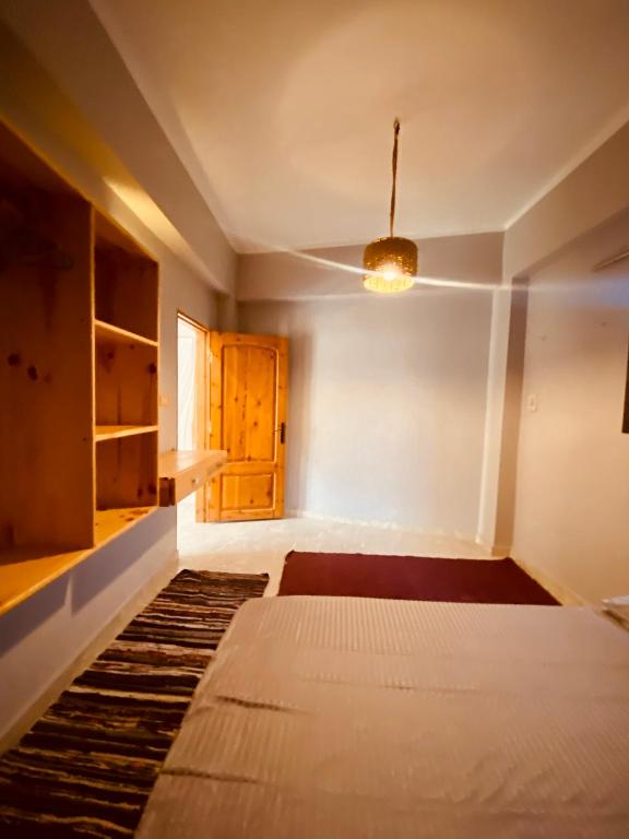 an empty room with a bed and a wooden door at El-sheikh Salem villa in Dahab