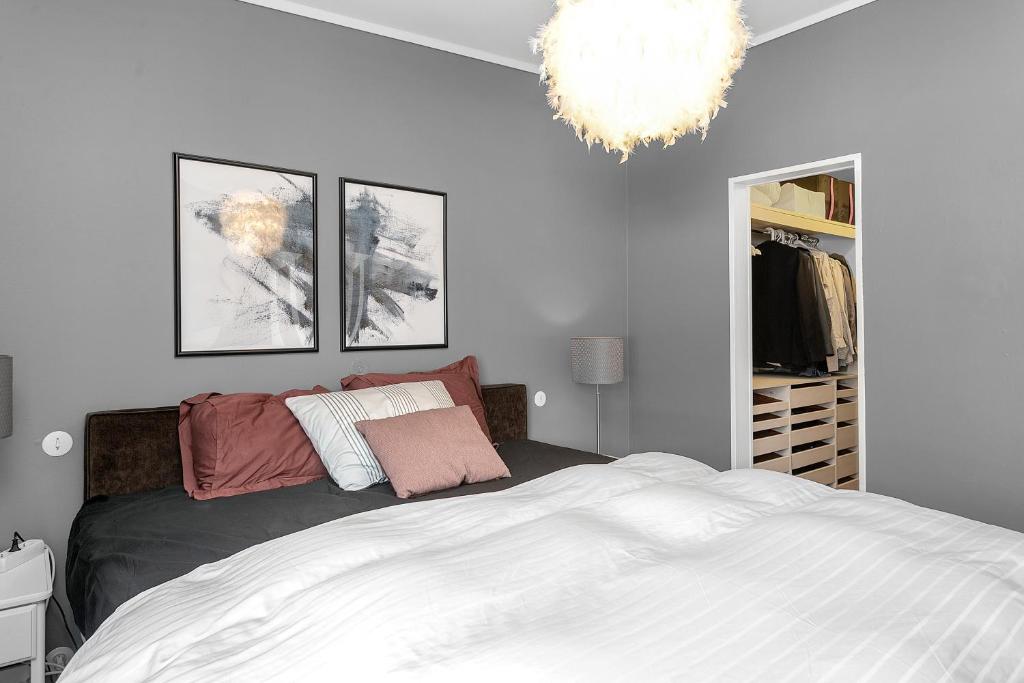 a bedroom with a bed and a chandelier at Family house with garden, Hot Tub Near Reykjavík in Garðabær