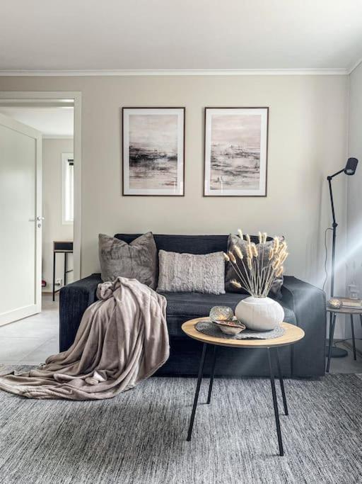 a living room with a blue couch and a table at Beautiful apartment near forest, sea and city in Sandefjord