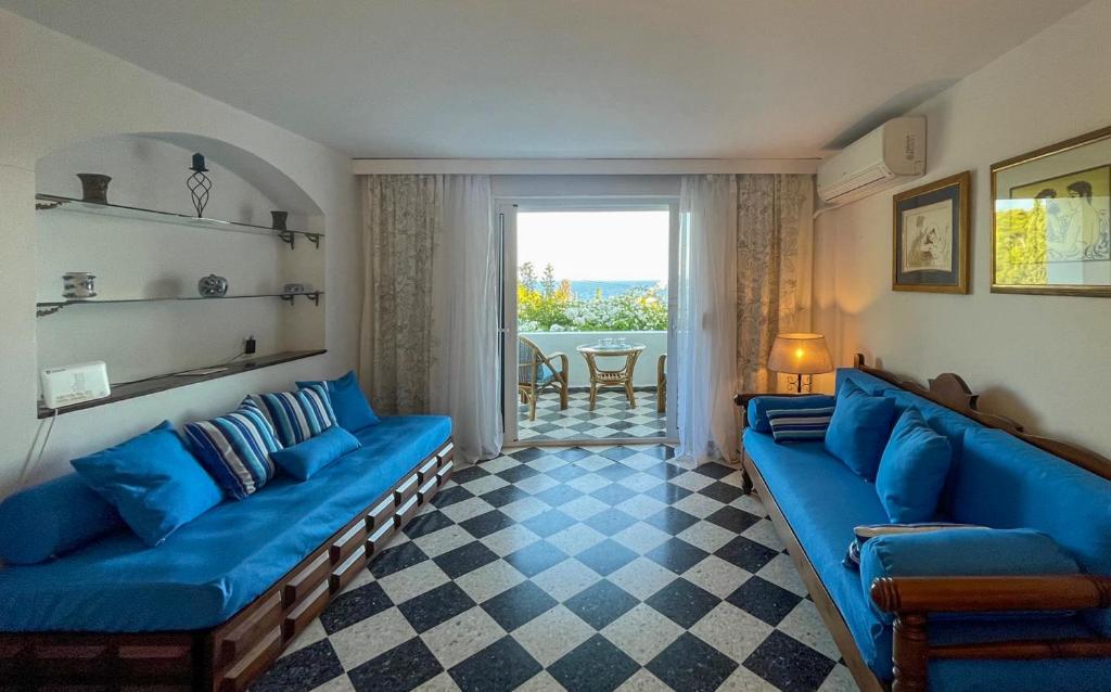 a living room with blue couches and a table at Casa Bianca Elegant House Near Beach in Spetses