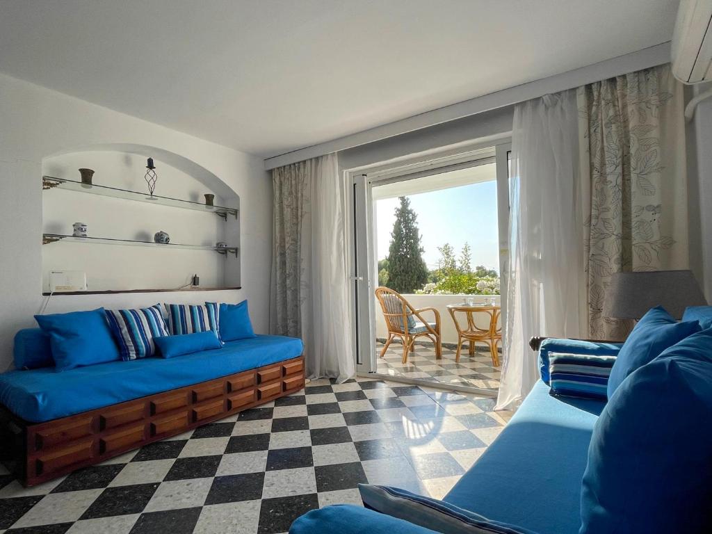 a living room with a blue couch and a window at Casa Bianca Elegant House Near Beach in Spetses
