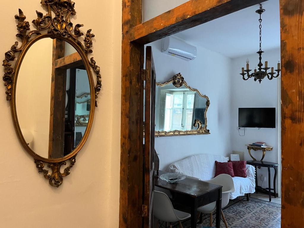 lustro na ścianie obok salonu w obiekcie FraLePorte Vintage Apartment w mieście Palermo
