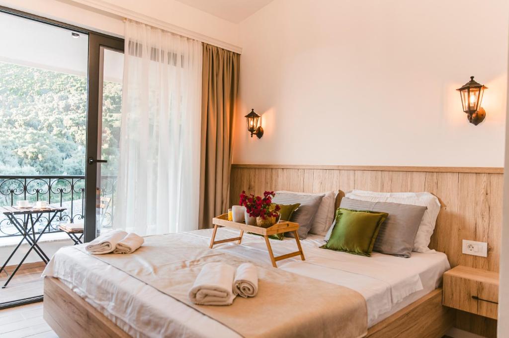 a bedroom with a large bed with a balcony at CAROLEA VILLAS in Ulcinj